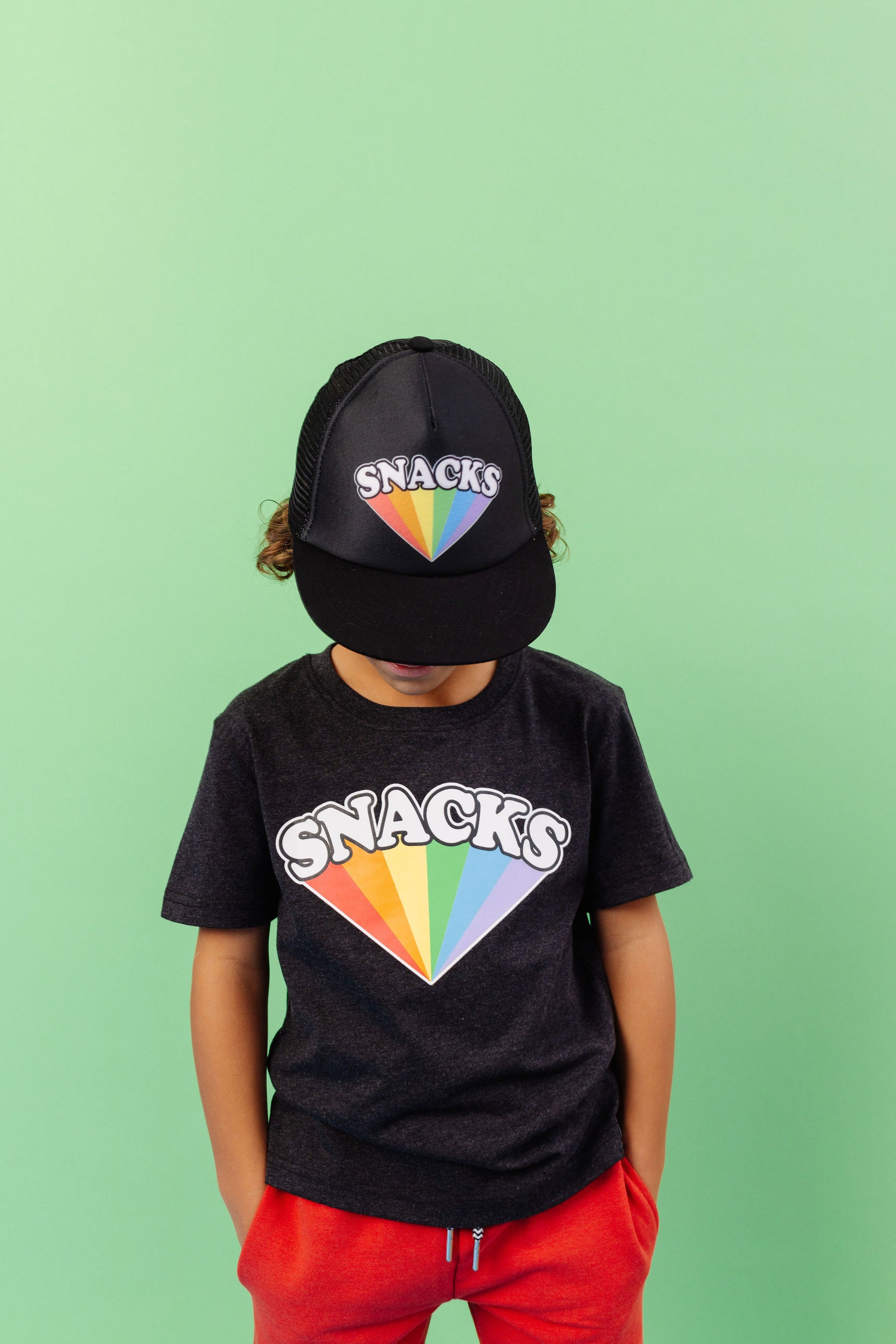 SNACKS Rainbow design screen printed in full colour onto a black flat brim snap back cap. Available in two sizes. Matching kids and adult t-shirts available.