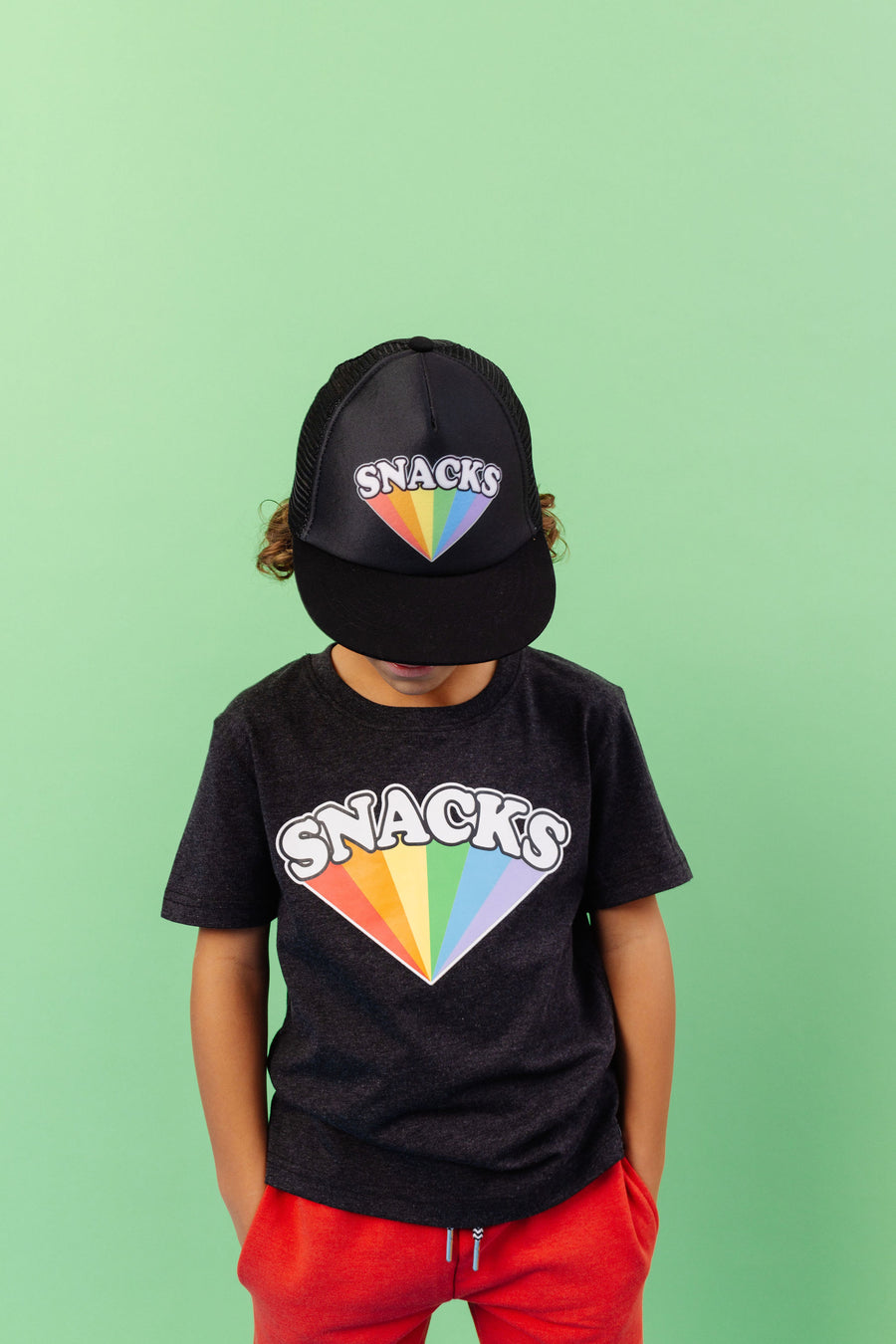 SNACKS Rainbow design screen printed in full colour onto a black flat brim snap back cap. Available in two sizes. Matching kids and adult t-shirts available.