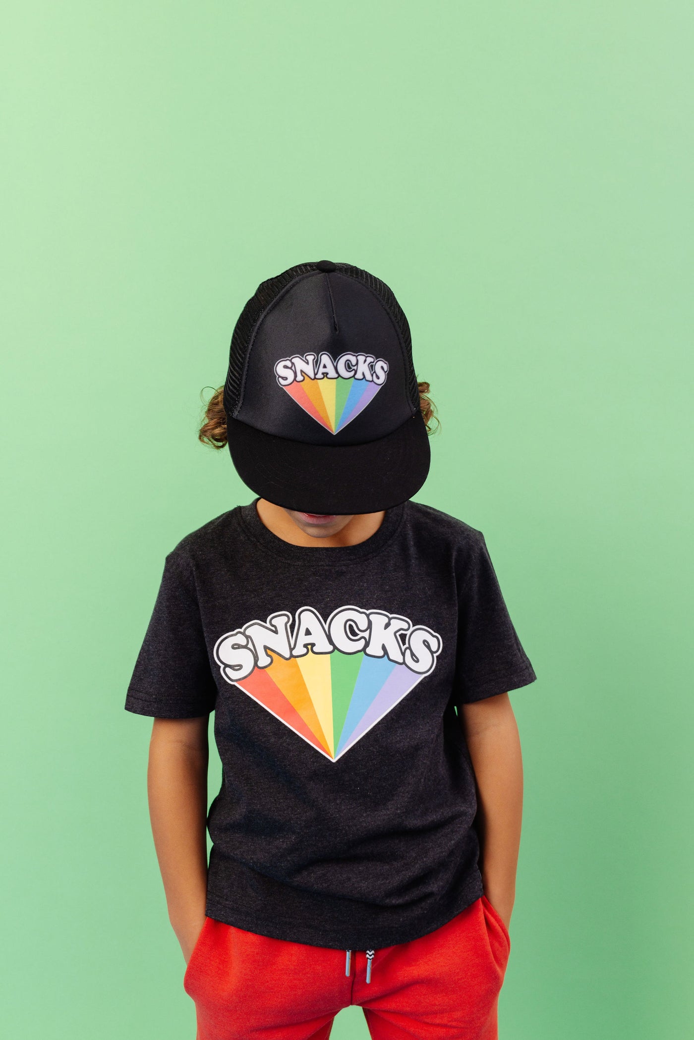 SNACKS Rainbow design printed on organic charcoal heather grey t-shirt. Paired with SNACKS Rainbow snap back hat and BEST bamboo joggers in red. Gender Neutral and available in kids and adult sizes.