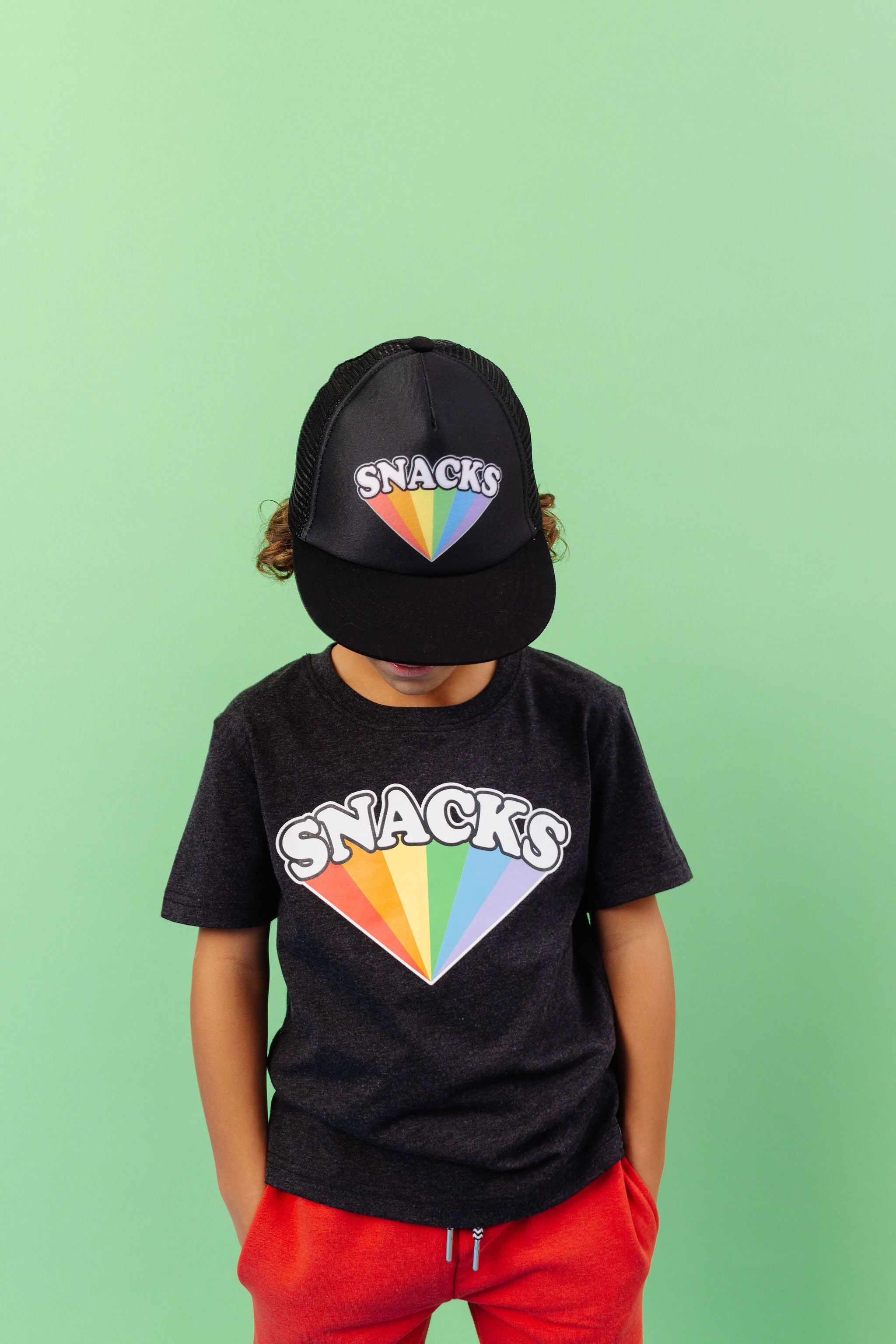 SNACKS Rainbow design printed on organic charcoal heather grey t-shirt. Paired with SNACKS Rainbow snap back hat and BEST bamboo joggers in red. Gender Neutral and available in kids and adult sizes.